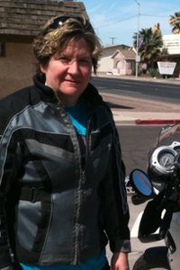woman standing outside near a motorcycle woman standing outside near a motorcycle