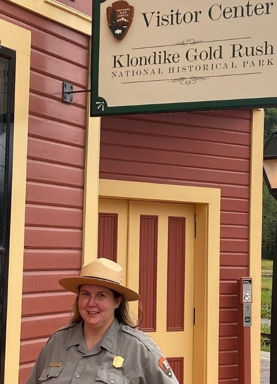 klgo wetz 2 a park ranger standing near a sign that reads visitor center klondike gold rush national historical park