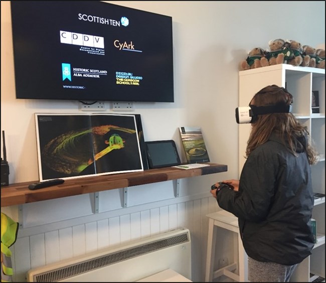 A visitor uses a virtual reality headset to learn about Scottish Heritage.