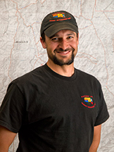 Jay Lusher stands in front of a map.