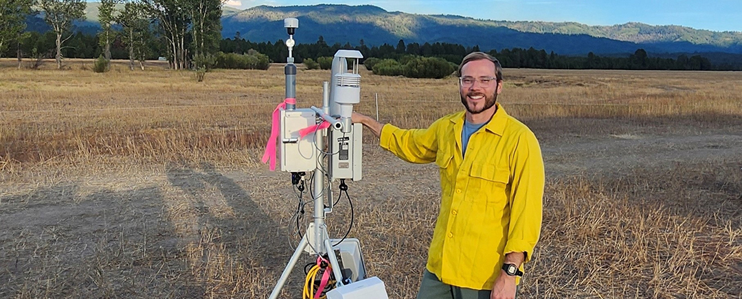 Seth Morphis A man in a yellow shirt stands next to a monitoring unit.