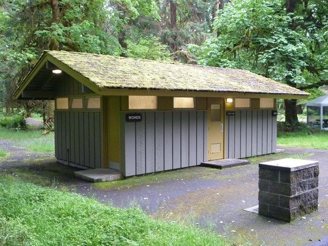 A Mission 66 era restroom building is gray with yellow trim