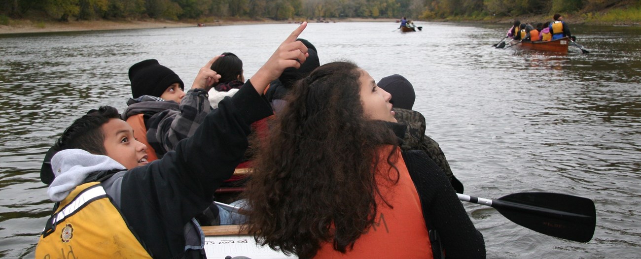 Students and staff in a Voyageur Canoe spot a bald eagle on a trip down the Mississippi River.