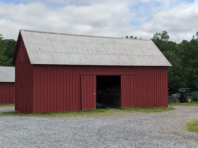 Red wooden building used to store hay and straw