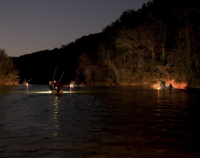 boats at night on river with giggers