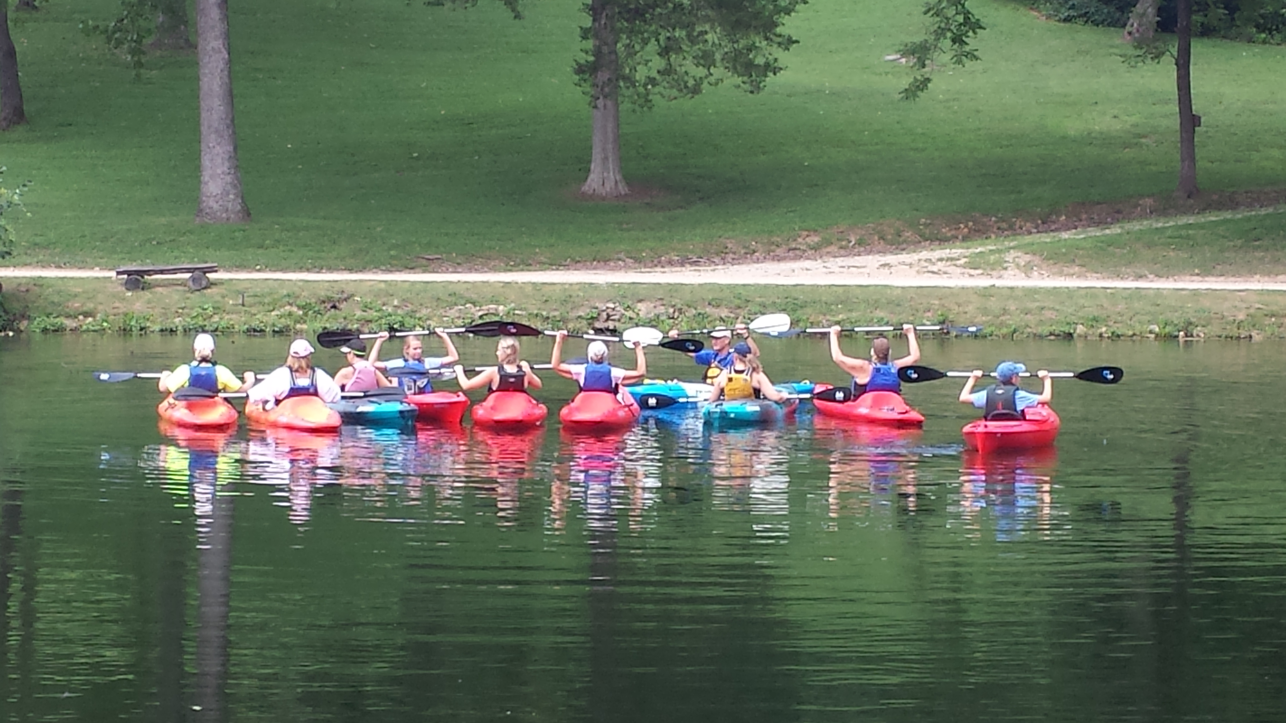 group of individuals in kayaks on lake