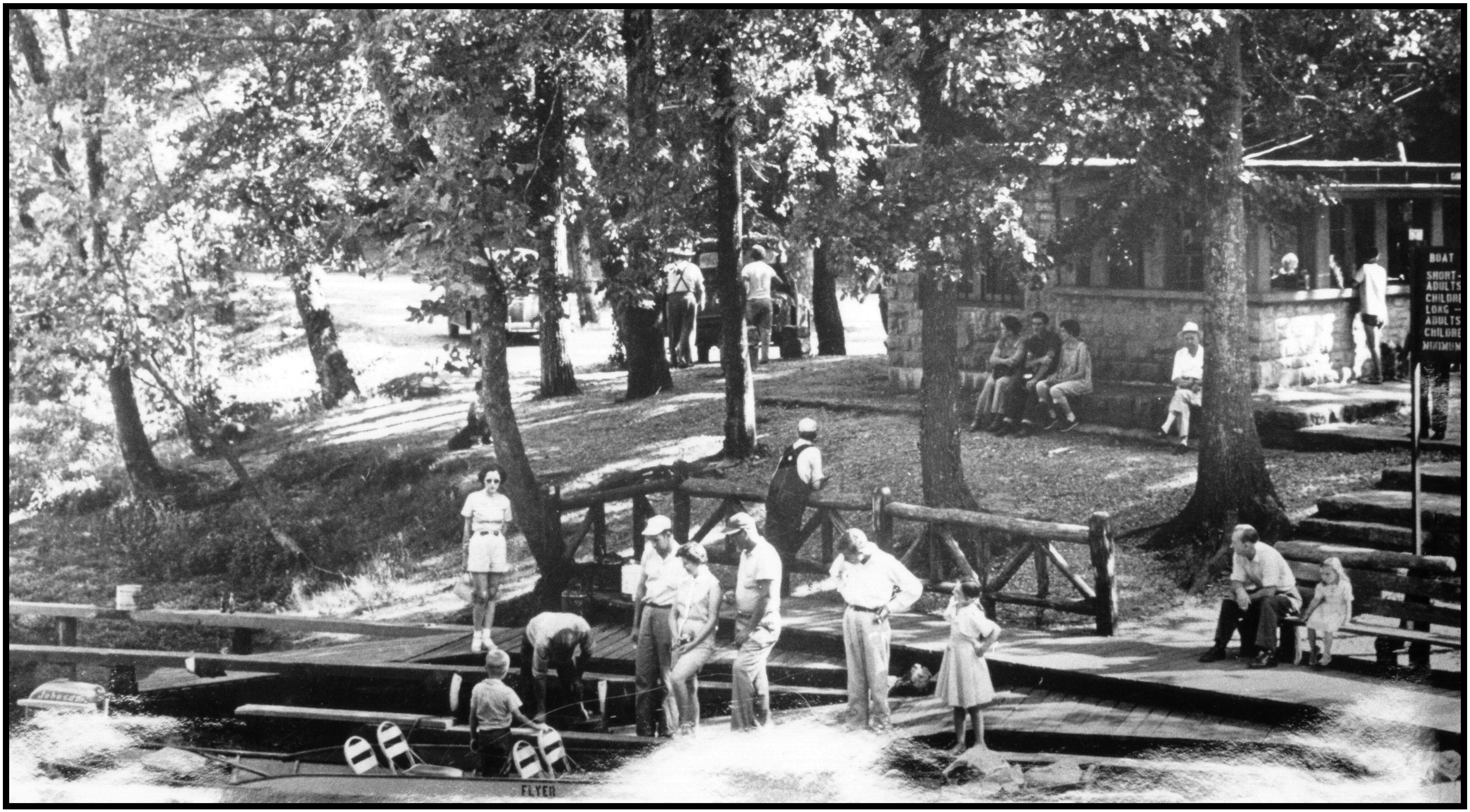 big spring lodge rock with wooden john boat in spring black and white photo