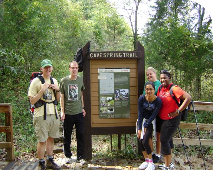 group of college students by cave spring trail head bulletin board