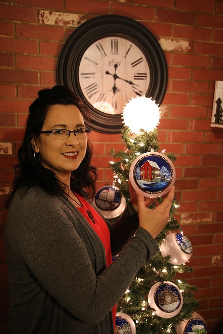 an artist holds a hand painted alley mill ornament