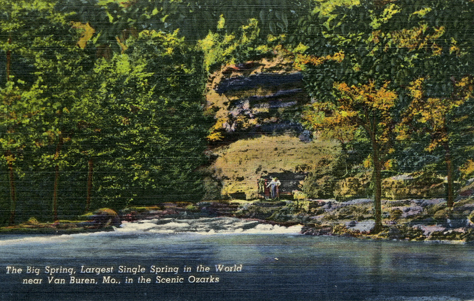 OZAR 55165 Big Spring Bluff-tif637014798010099857 An old fashion color tintype postcard of big spring showing a bluff and spring pouring from the base. People are standing on the edge of the spring. Text reads: The Big Spring, Largest single spring in the World near Van Buren, Mo, in the Scenic Ozarks
