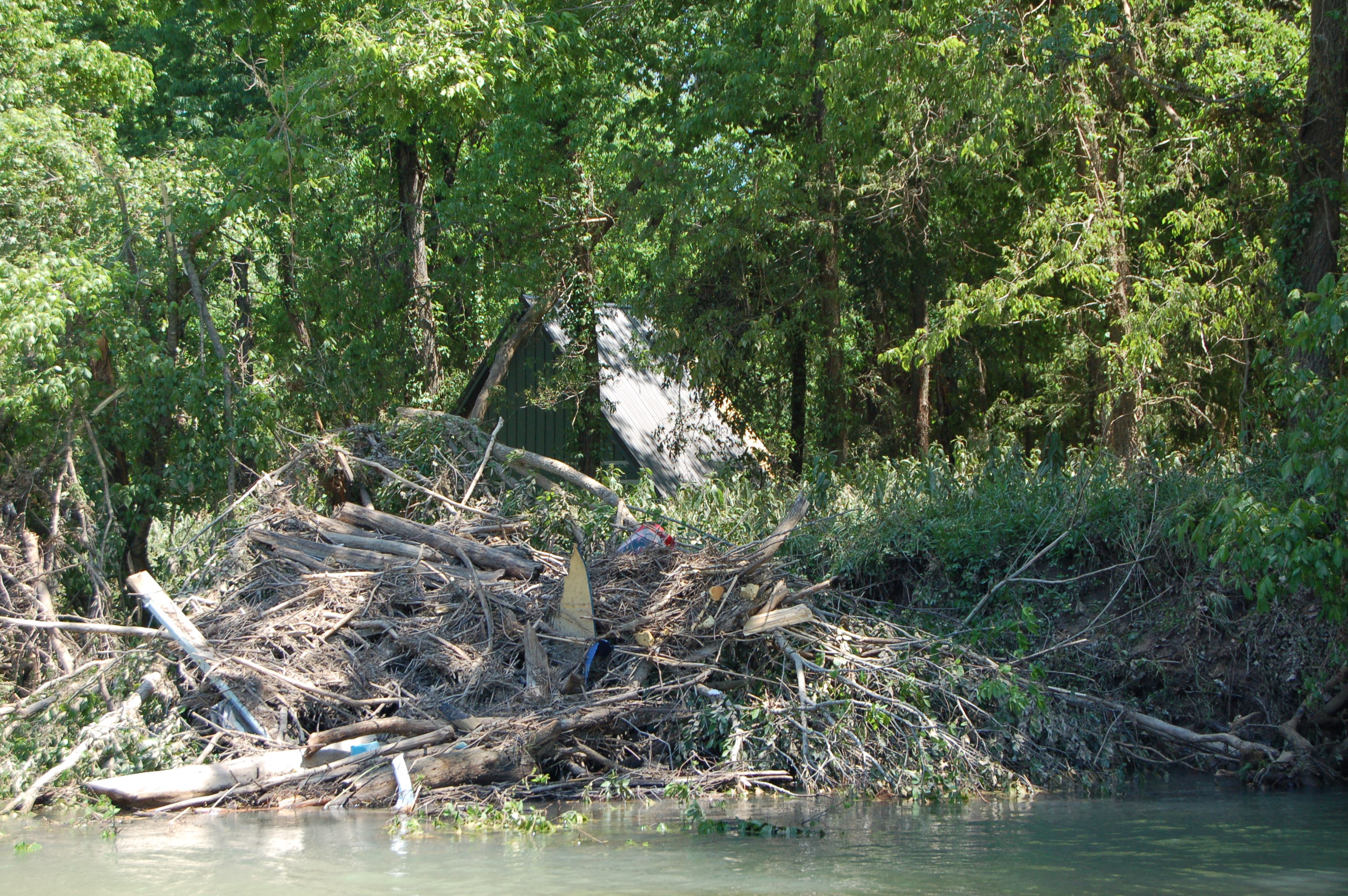 flood debris in river piled up next to water