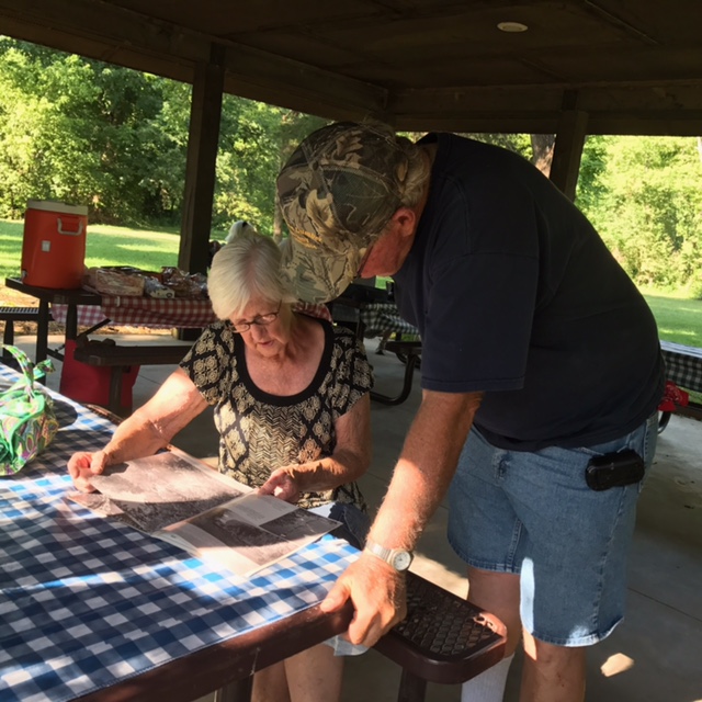 participants looking over memorabilia at a picnic table
