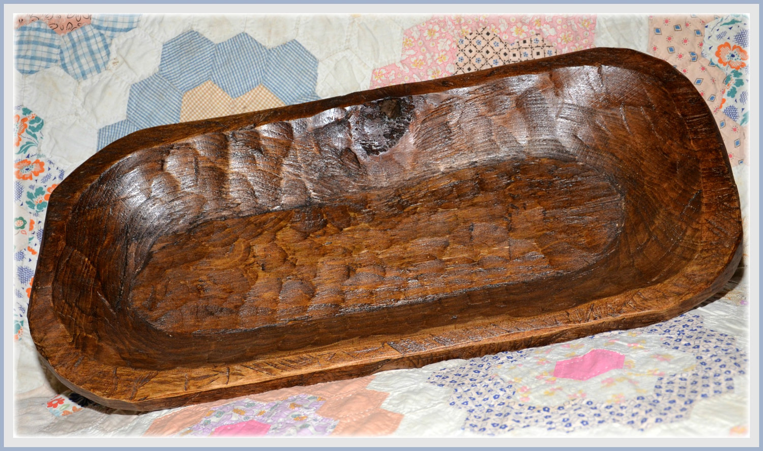 Shallow "trencher" dough bowl stained on a quilt