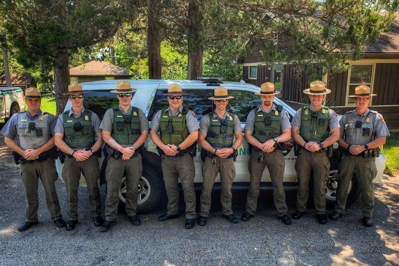 Ozark Law Enforcement Officers standing in uniforms in front of patrol vehicle