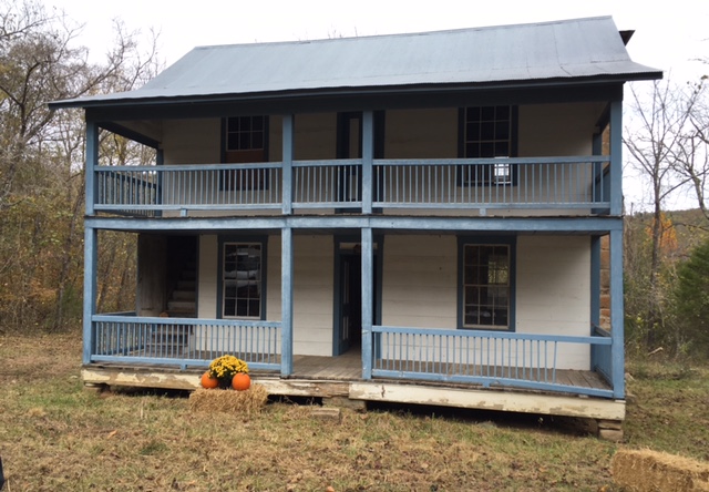 historic white double level house with blue trim