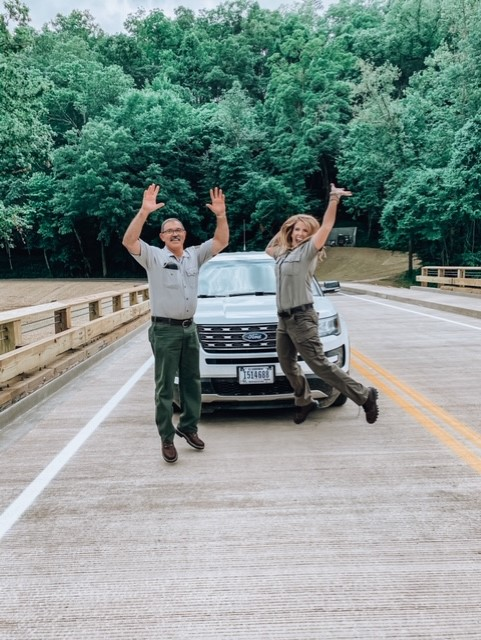 download (166) Two park staff on bridge in front of vehicle jumping up