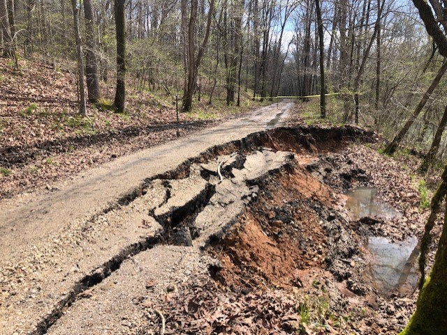 thumbnail_IMG_8747 a photo of a gravel roadway that has partially collapsed into a creek