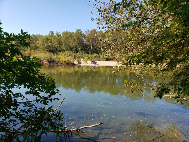 A clear river surrounded by fall colors in the hardwood forest