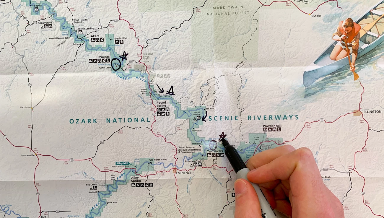 Grab a park map at ranger stations or bulletin boards throughout the park. A person uses a sharpie to draw on a park map.
