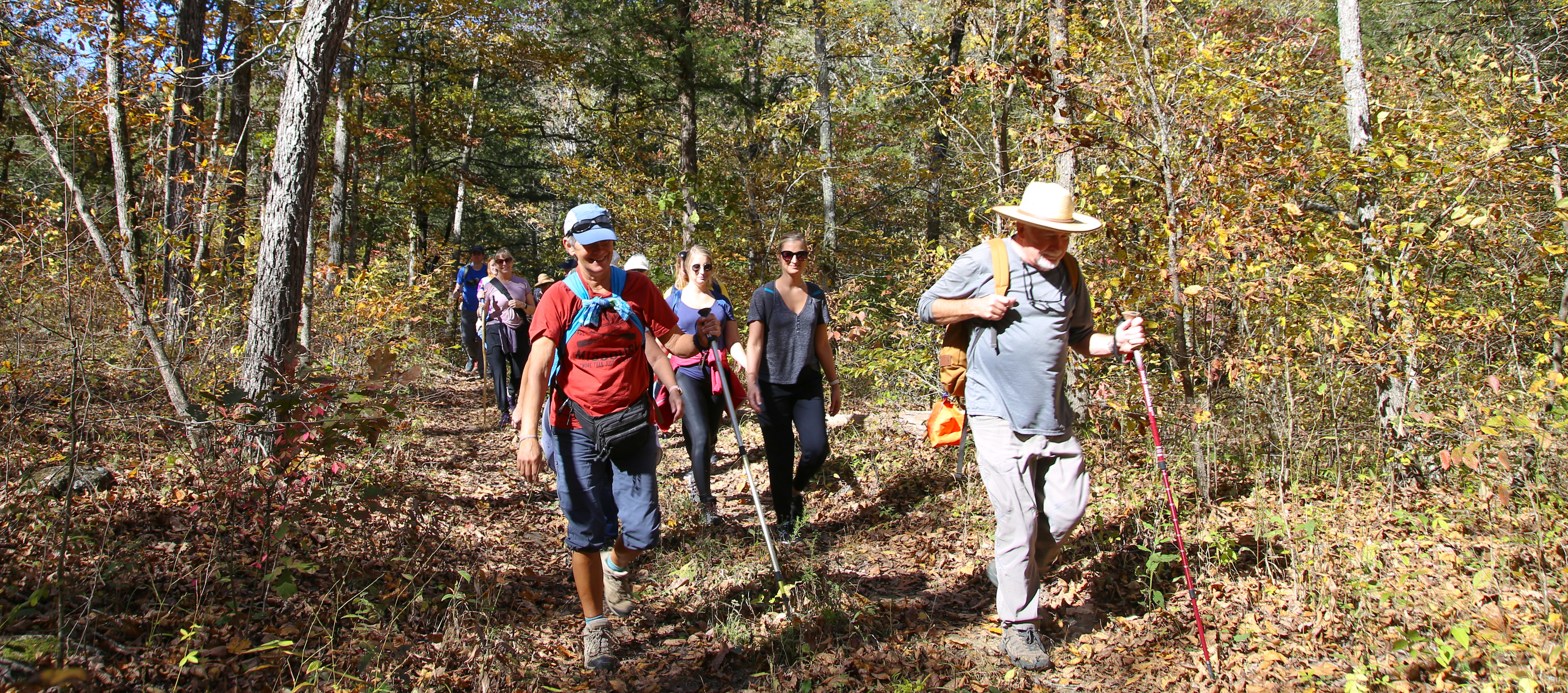 A man leads a group of people through the woods.
