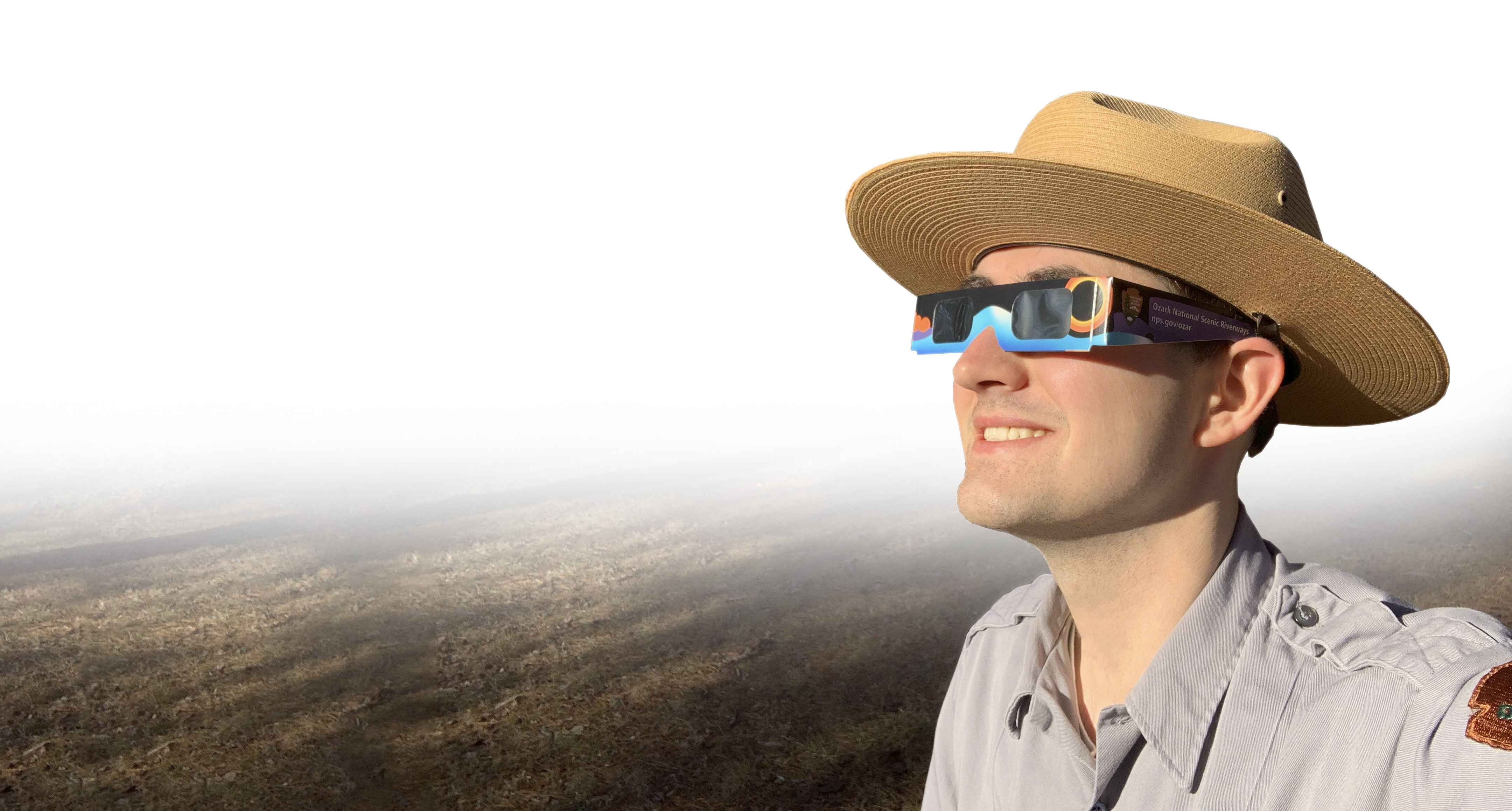 A park ranger wearing a pair of eclipse glasses.