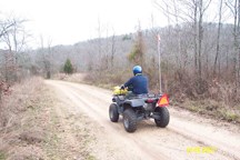 man on atv riding on dirt road