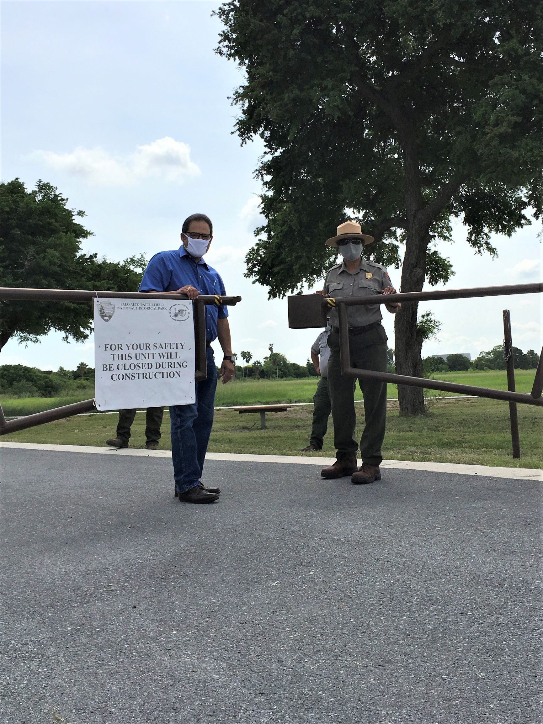 Male in civilian clothes and female in Ranger uniform opening a gate.