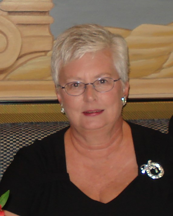 Portrait of female with short white hair, glasses, and a black blouse