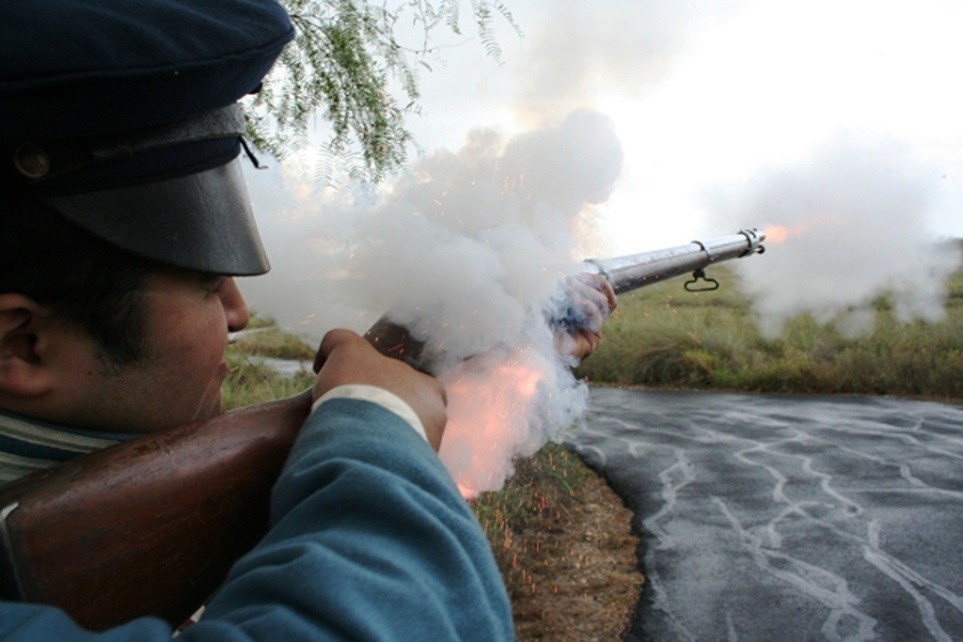 Sparks and flames shoot out as a living historian fires a musket.