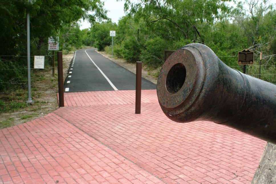 hike and bike trail Cannon in foreground with trail entrance in the background