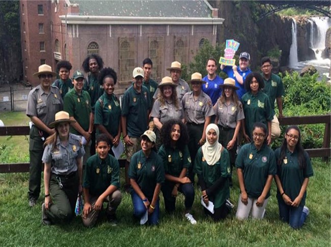 2016 Rangers and GFYC Park Rangers pictured with GFYC Members, with waterfall visible in the back right of the picture.