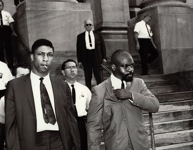 Hurricane Carter exiting court house Rubin "Hurricane" Carter exiting court house with 5 police officers. To Rubin Carter's right is John Artis.