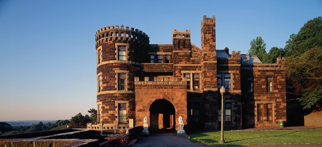 A picture of the outside of Lambert Castle at sunset