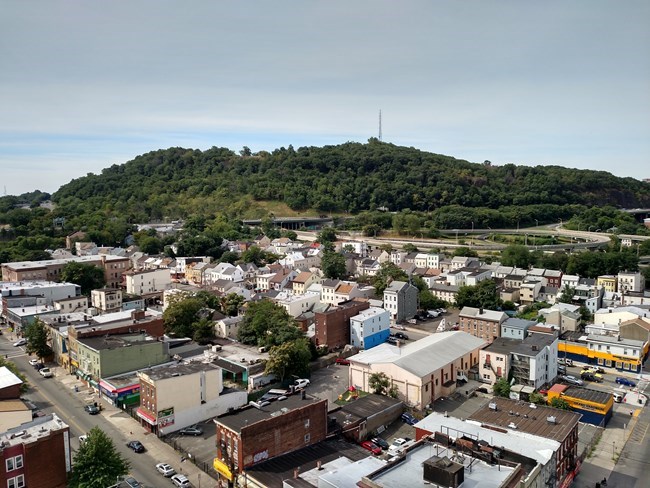 A sunny summer day color picture of houses and buildings of the South Dublin neighborhood, with mountains in the background.