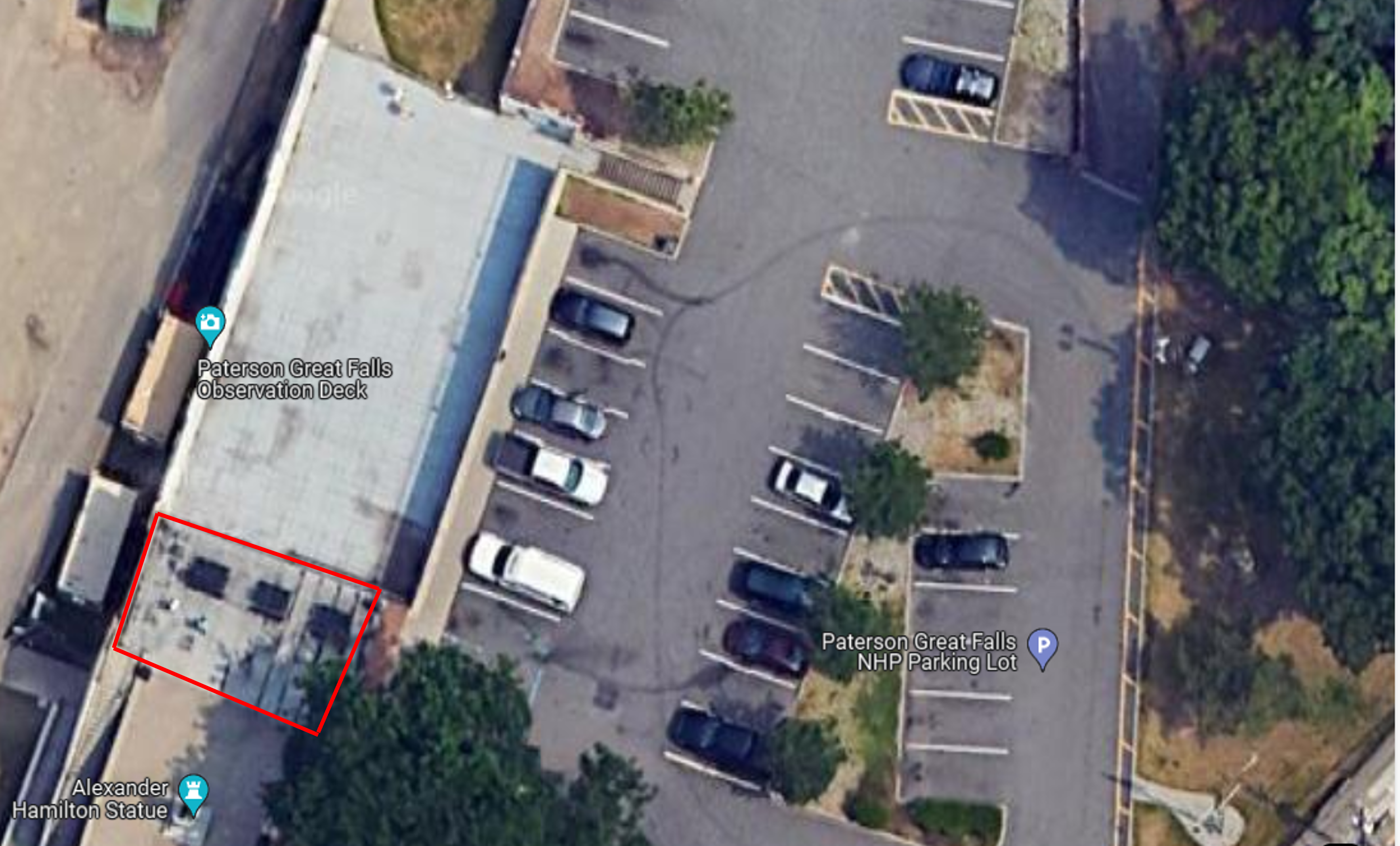 A satellite map view of the parking lot at Paterson Great Falls National Historical Park, located at 72 McBride Avenue Extension, Paterson NJ 07501. The upper, northern half of the lot is outlined with a red polygon, marking a First Amendment zone.