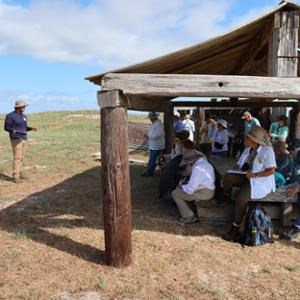Group of people sitting while listening to a volunteer talk.