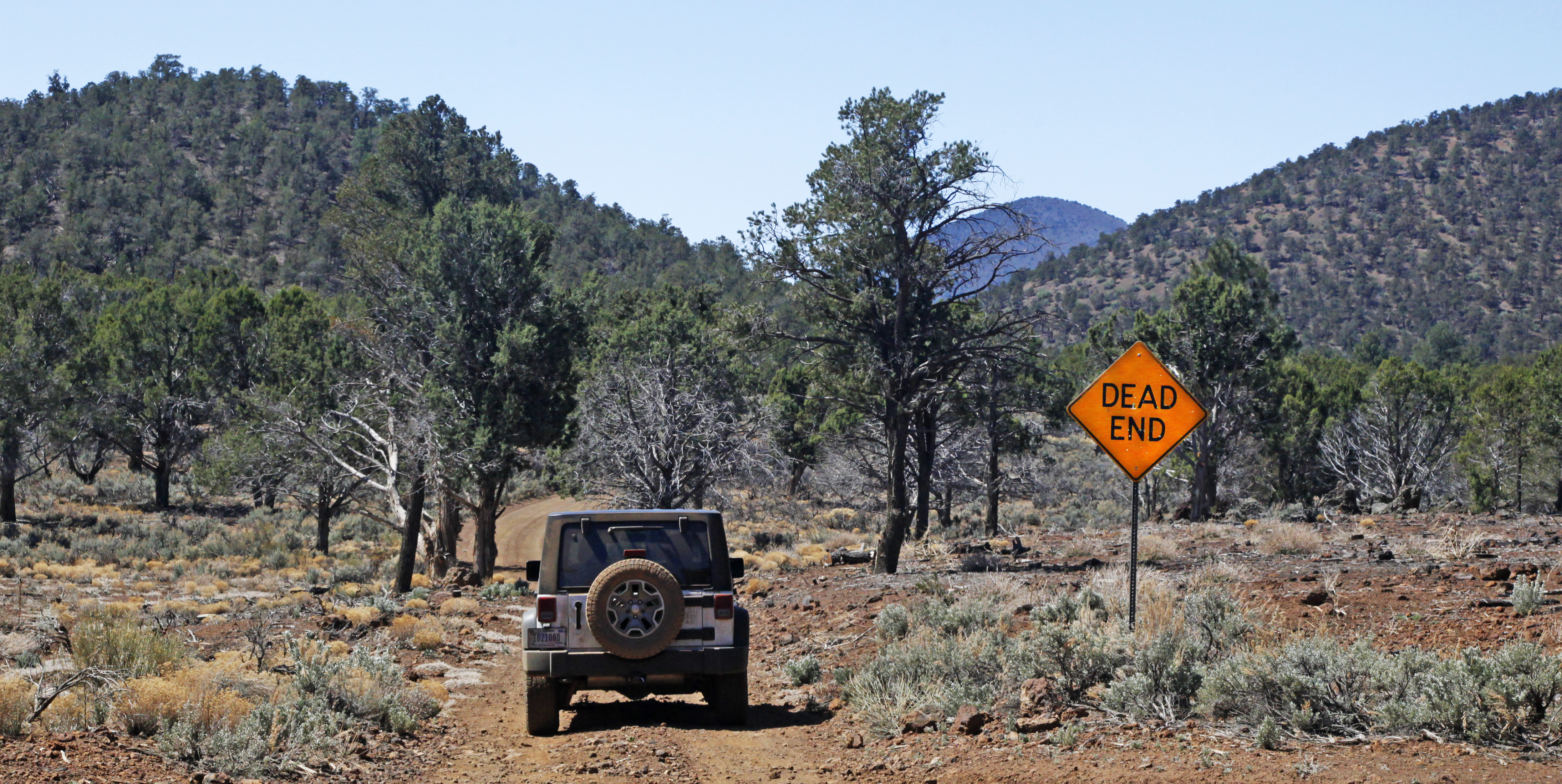 Jeep at 4 way intersection with Dead End sign