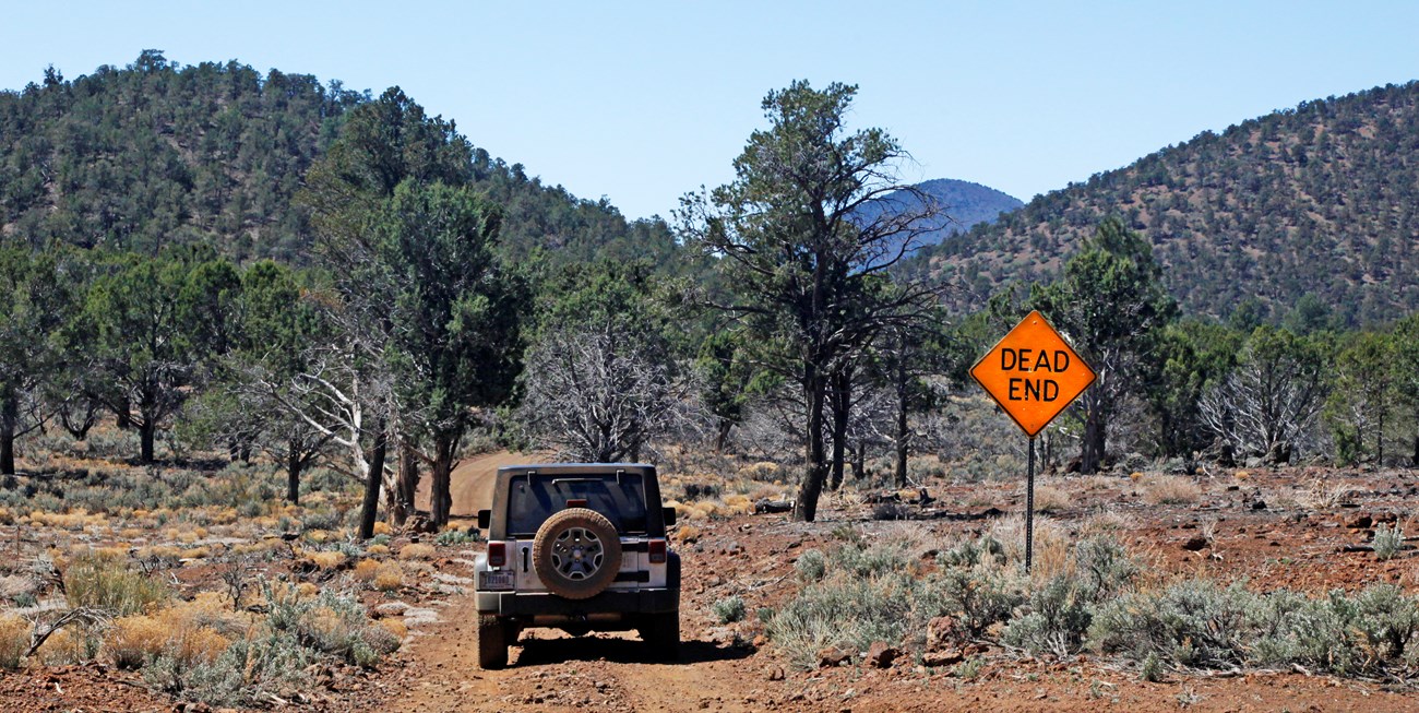 Jeep at 4 way intersection with Dead End sign