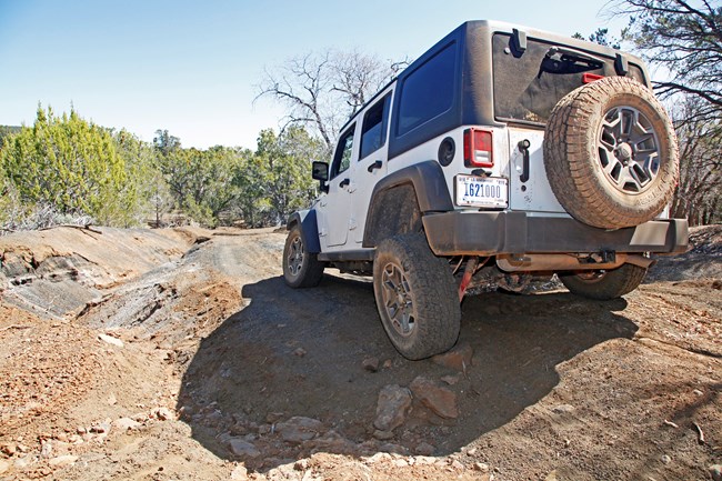 Jeep on washed out road going across ditch