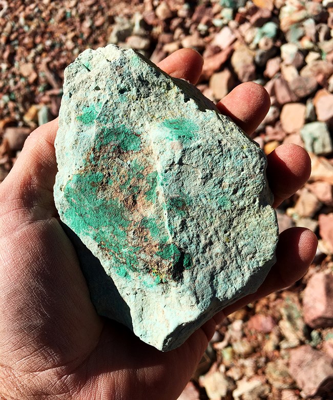 The green coating on this limestone rock is called malachite, a form of copper ore.