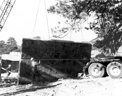 Concrete and stone panels are brought onto the site by the aid of crane with 2 construction workers