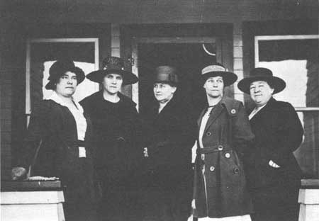 women officeholders standing on porch