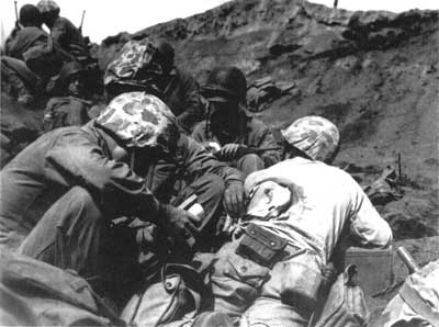 Navy corpsmen tending to wounded Marine
