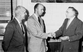 Al Edmunds, Cooperative Activities Regional Chief looks on as Howard Chapman receives a handshake with Daniel Tobin.