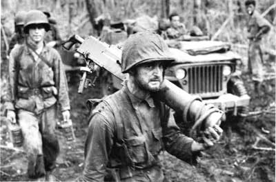 PFC George C. Miller carrying weapon