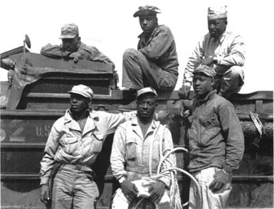 Marines pose with Army DUKW amphibious trucks