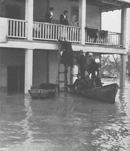 CCC enrollees in boat evacuating people stranded by flood waters