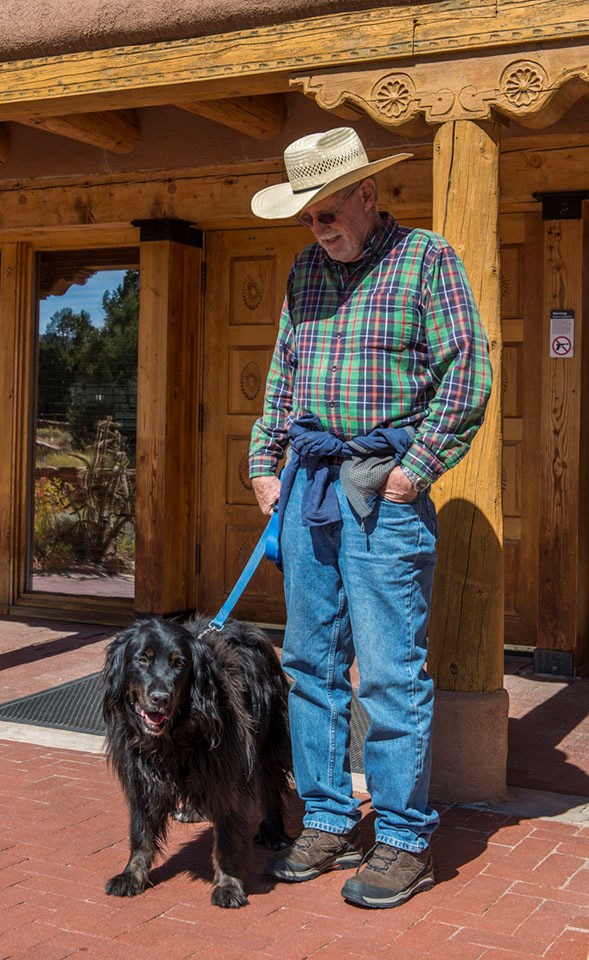 Perfect place for a walk man standing next to his black dog