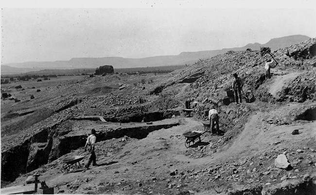 men digging in large deep trench
