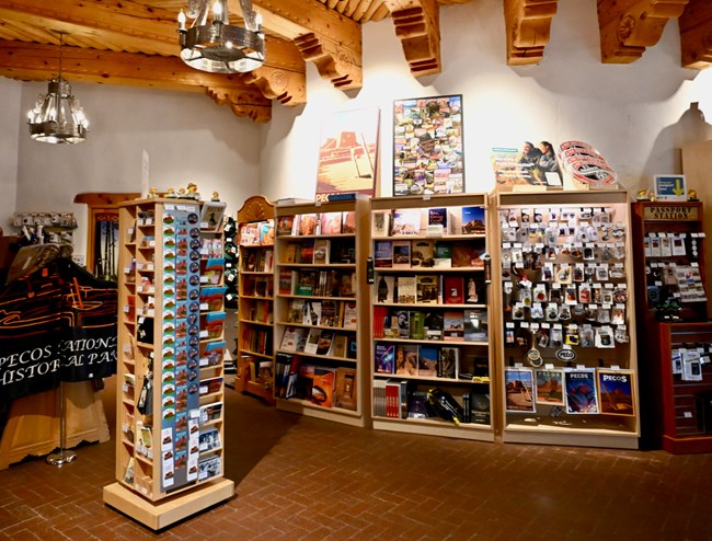 Three bookshelves full of books, a spinning rack of magnets a sticker display, etc.